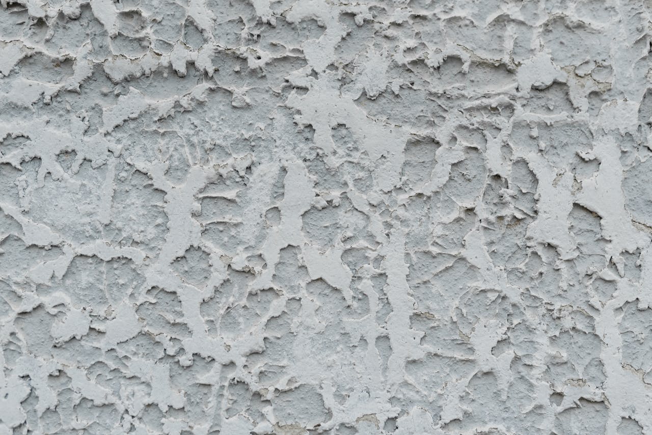 Close-up of a textured stucco wall with weathered, rough patterns and grunge look.