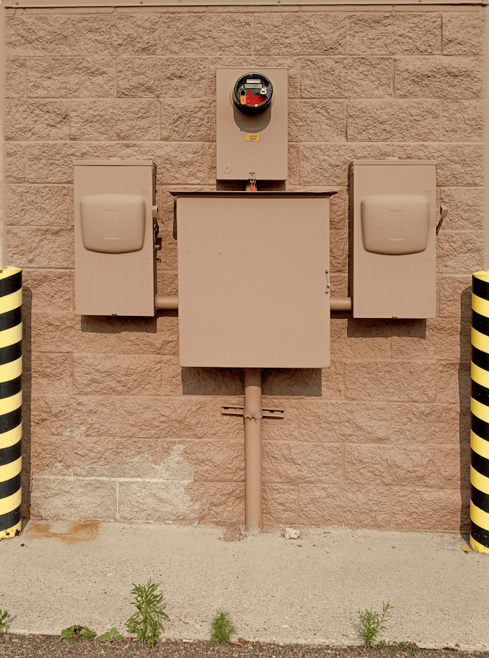 robot-up-against-the-wall-27970882 Industrial electrical fuse box with warning stripes on an urban wall.