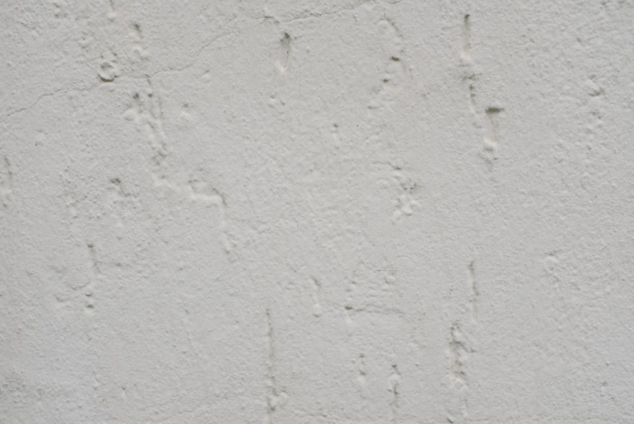 Closeup background of white plaster wall surface with uneven texture